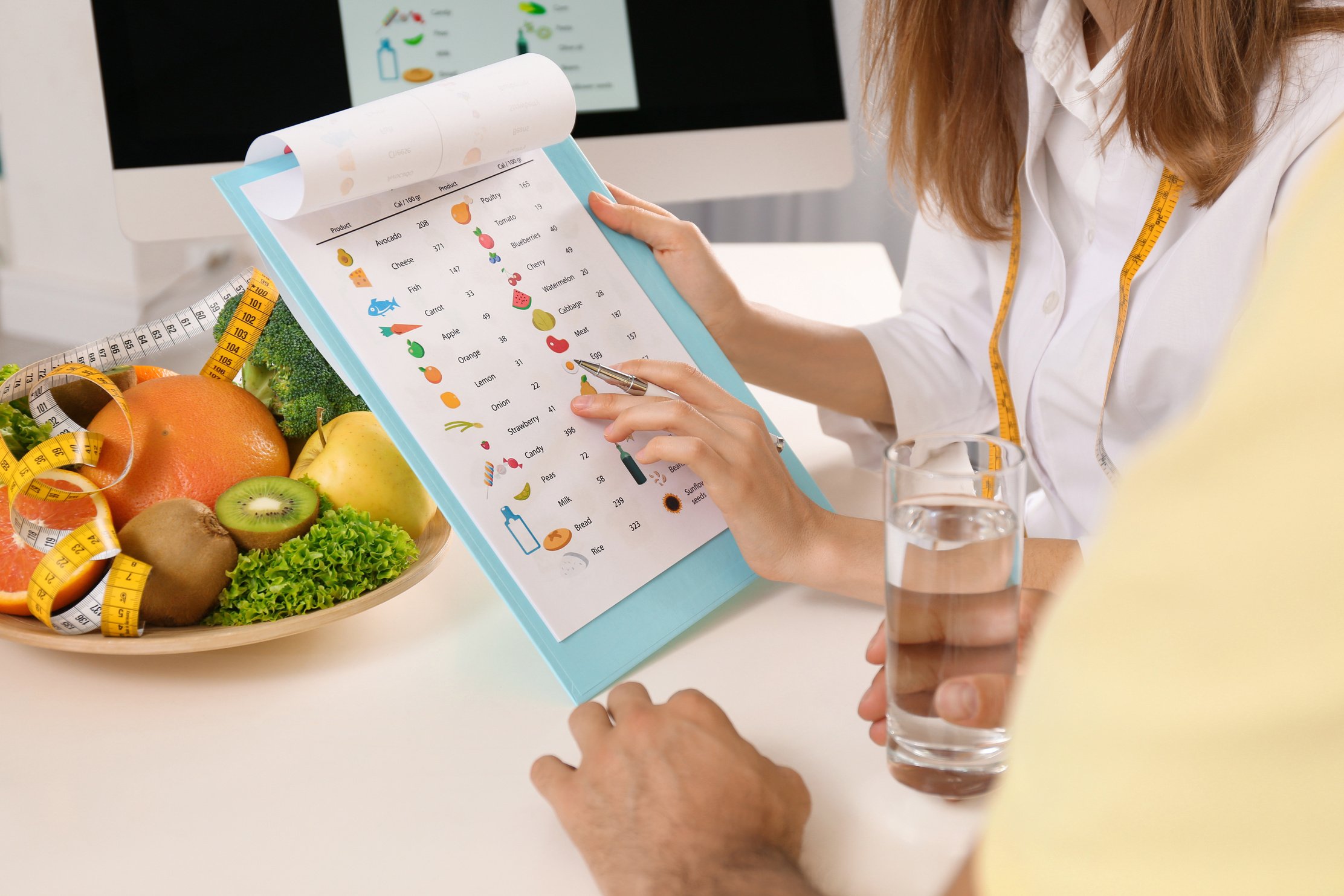 Young Nutritionist Consulting Patient at Table in Clinic, Closeu